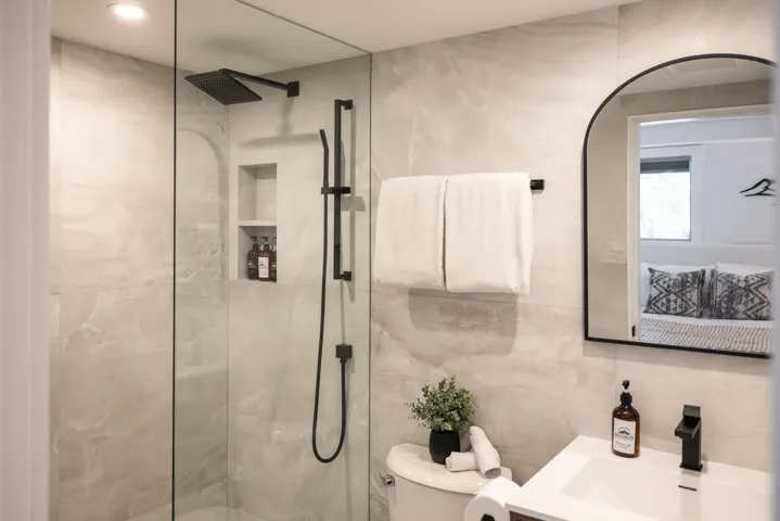 Full bath featuring vanity, tile walls, toilet, and a walk in shower