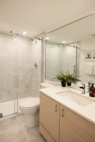 Full bathroom with a shower stall, toilet, and vanity