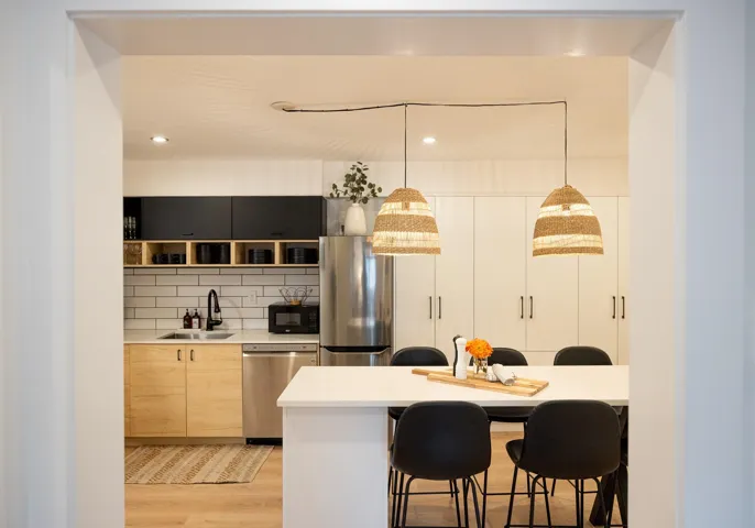 Kitchen featuring light wood-style flooring, a sink, backsplash, stainless steel appliances, and light countertops