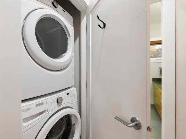 Laundry room featuring stacked washer / drying machine and laundry area