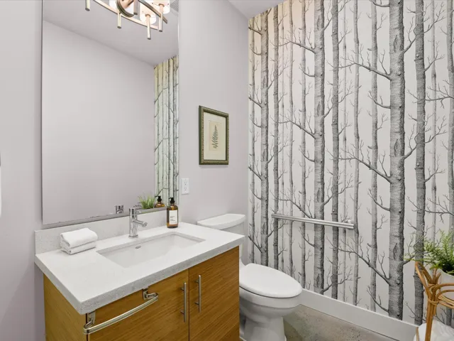 Bathroom featuring vanity, a shower stall, toilet, and a chandelier