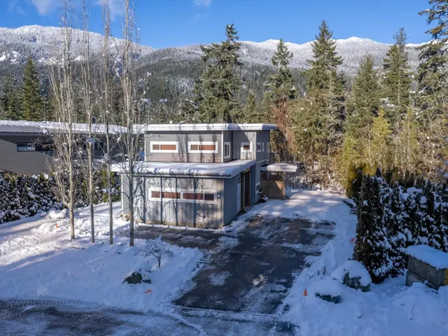 View of front of property with a mountain view and a view of trees