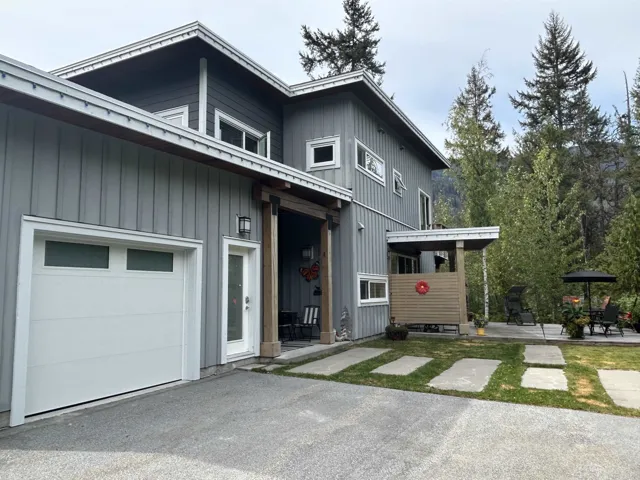 Modern exterior with vertical siding, a covered entry, and a white garage door