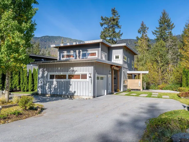View of front facade with board and batten siding, a mountain view, asphalt driveway, and a garage