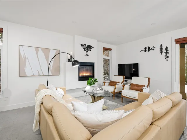 Living area with a glass covered fireplace and baseboards