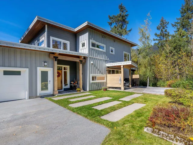 View of front of house featuring board and batten siding, a front lawn, and a garage