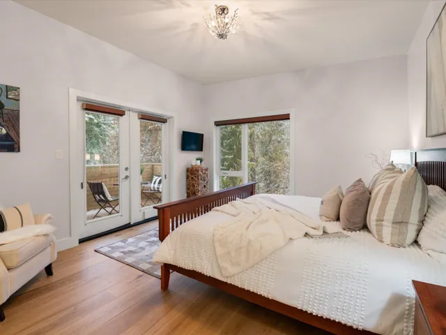 Bedroom featuring french doors, a chandelier, access to exterior, and light wood finished floors