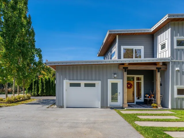 View of front facade with driveway, board and batten siding, covered porch, and a garage