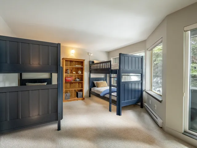 Bedroom with light carpet and a baseboard heating unit