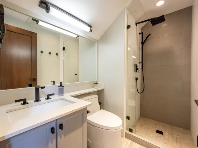 Bathroom featuring toilet, vanity, recessed lighting, and a shower stall