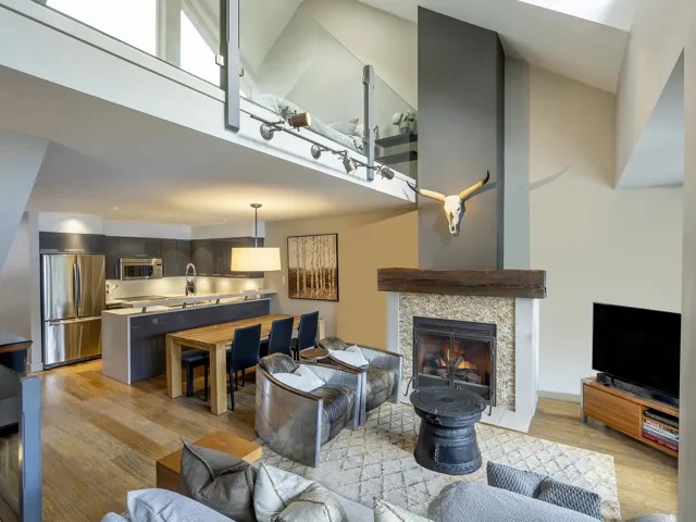 Living room featuring a fireplace, a towering ceiling, and light wood finished floors