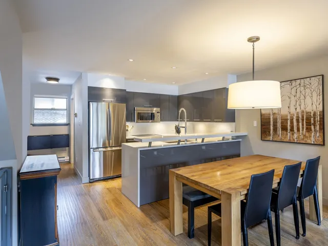 Kitchen featuring light countertops, a sink, stainless steel appliances, and modern cabinets