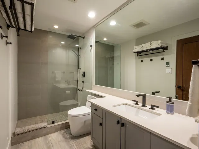 Bathroom with vanity, recessed lighting, toilet, visible vents, and tiled shower