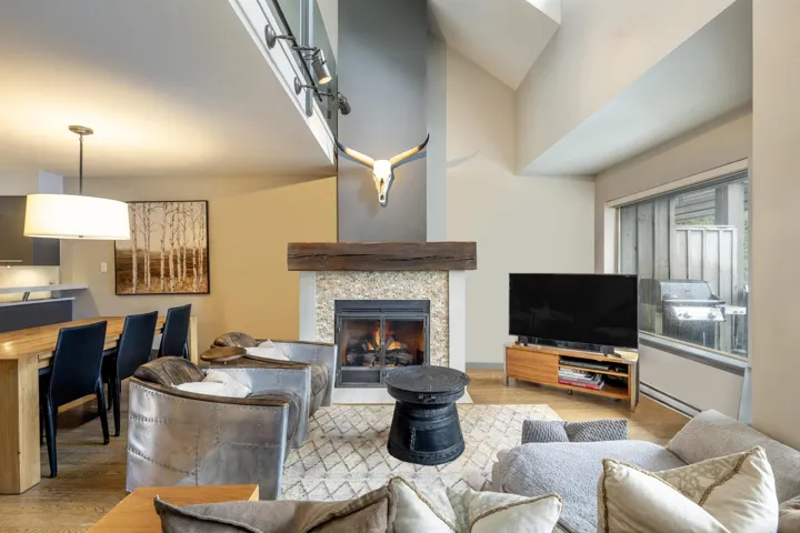 Living room featuring a high ceiling, wood finished floors, and a tile fireplace