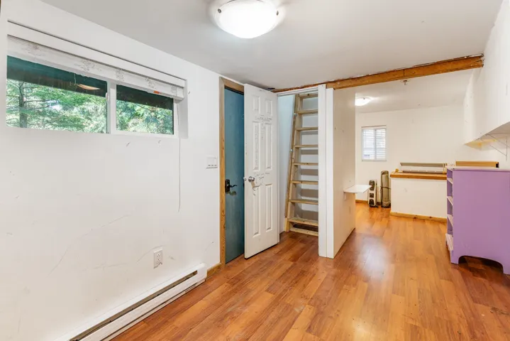 Wood-finish flooring, exposed wood beam, and a built-in ladder