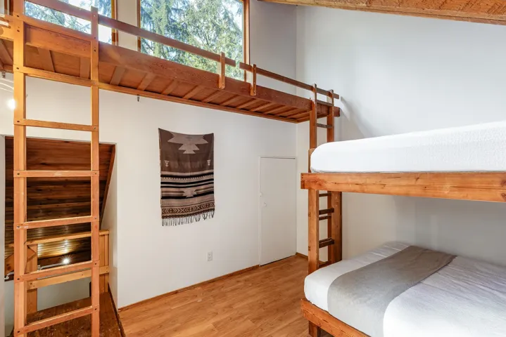 Wood-finish flooring with a multi-level layout, featuring a lofted space and a bunk bed