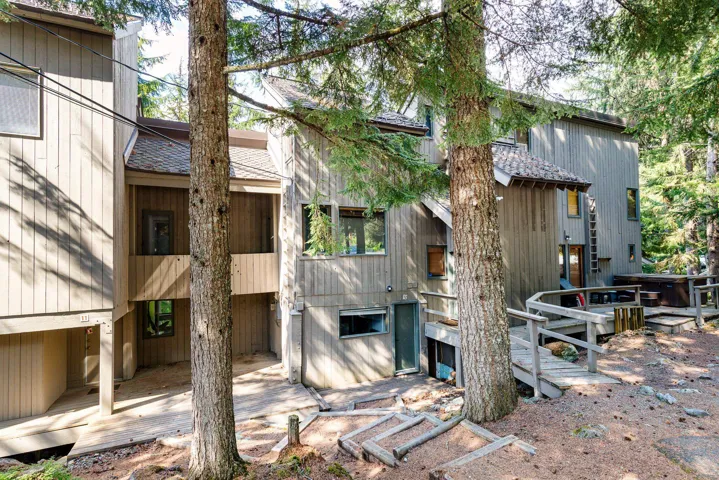 Wood-sided exterior structure with multiple window types, including a distinct bay window