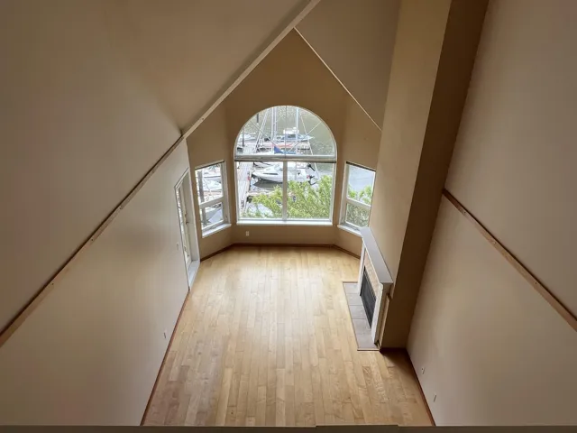 Additional living space featuring light wood-style flooring and high vaulted ceiling
