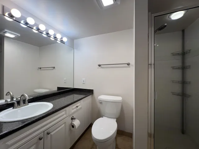 Full bath with toilet, a stall shower, tile patterned flooring, vanity, and baseboards