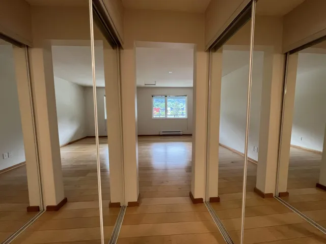 Hallway with light wood finished floors and a baseboard radiator