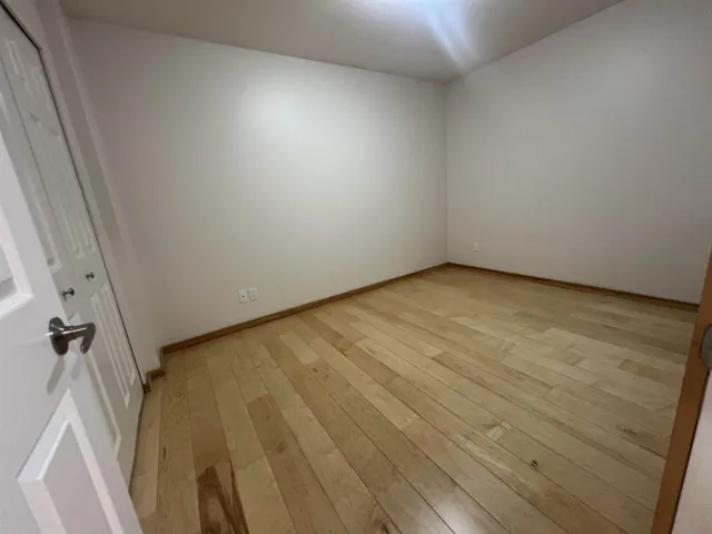 Unfurnished room with light wood-style flooring and baseboards