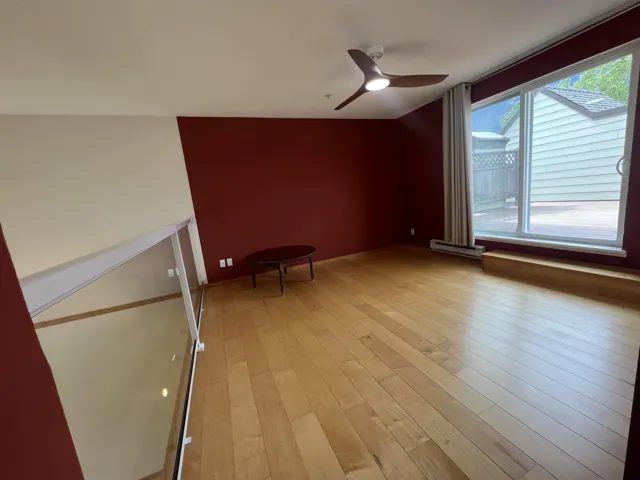 Bonus room with light wood-style floors, ceiling fan, and baseboard heating