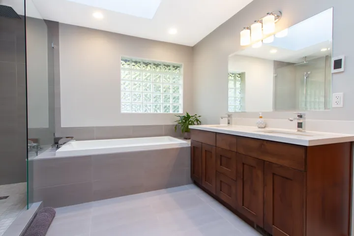 Full bath with a bath, a skylight, a sink, and tiled shower