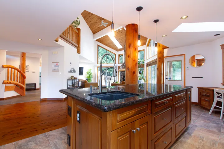 Kitchen featuring plenty of natural light, open floor plan, a skylight, and a sink