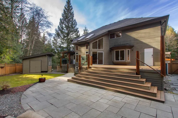 Rear view of house featuring a patio, a storage shed, an outdoor structure, fence, and a lawn