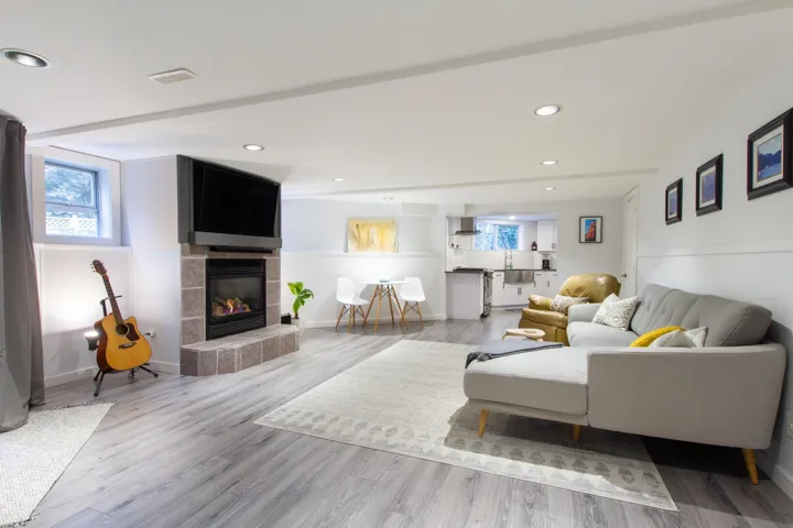 Living room with wood finished floors, a wealth of natural light, and a tile fireplace