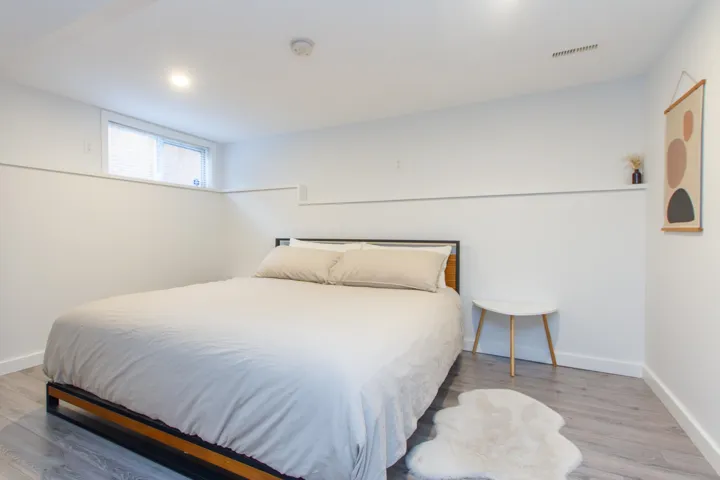 Bedroom with wood finished floors, visible vents, and baseboards