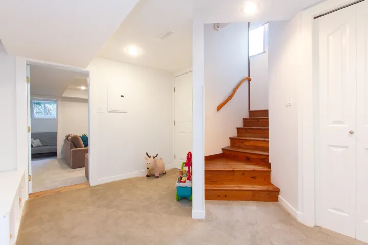 Interior space featuring electric panel, carpet, visible vents, and baseboards