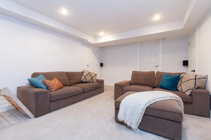 Living area with carpet floors, recessed lighting, a tray ceiling, and baseboards