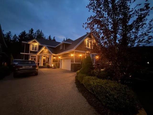 Shingle-sided residence featuring a prominent gabled roofline, a two-car garage with an automatic door, and a concrete driveway