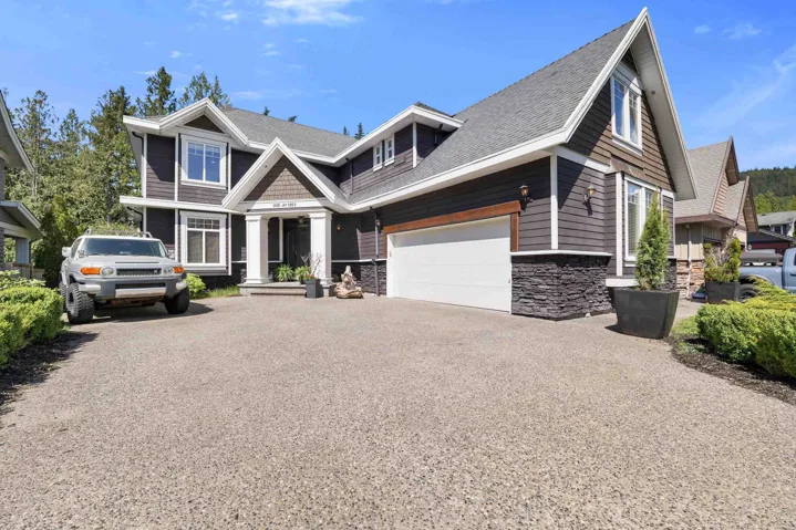 Contemporary home exterior featuring dark siding, white trim, and a prominent gable roofline