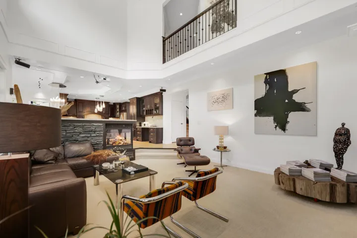 Open-concept living area featuring a two-story ceiling, recessed lighting, and a second-level balcony with metal balusters