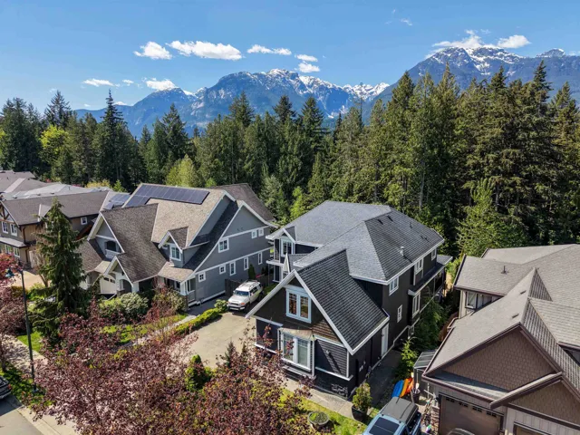 Residential street featuring multiple properties with pitched roofs and varying siding materials