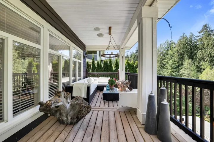 Expansive outdoor deck featuring wood-finish flooring, white ceiling panels, and black railing