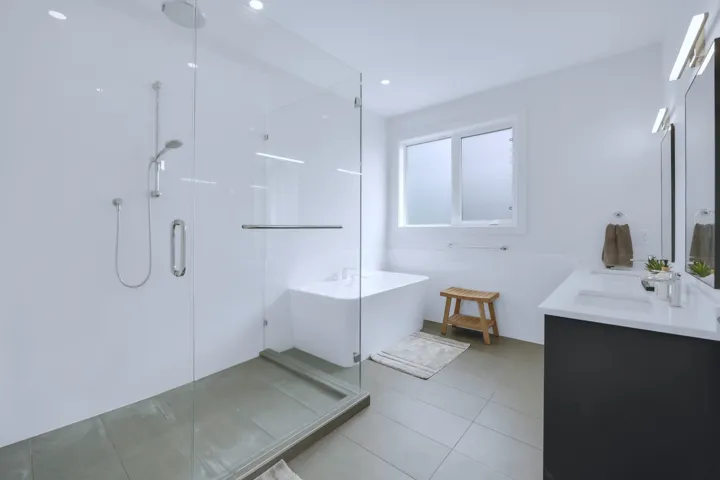 Full bath featuring an enclosed shower, a soaking tub, a sink, and double vanity