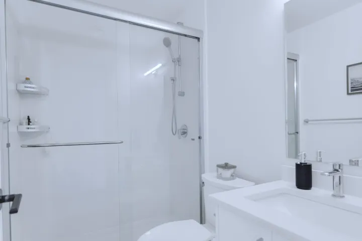 Bathroom featuring vanity, toilet, and a stall shower