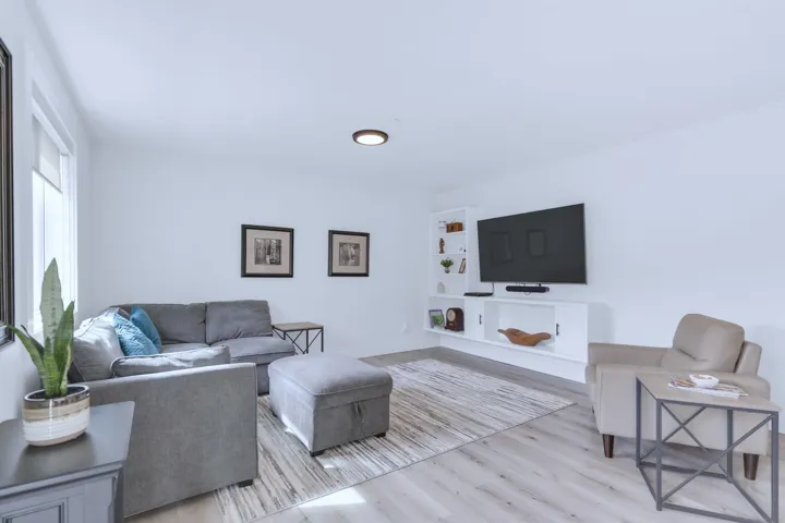 Living room featuring built in shelves and light wood-style flooring