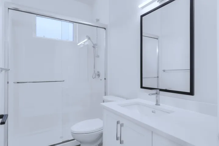 Bathroom with a shower stall, toilet, and vanity