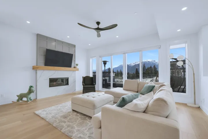 Living room featuring a ceiling fan, wood finished floors, recessed lighting, and a high end fireplace