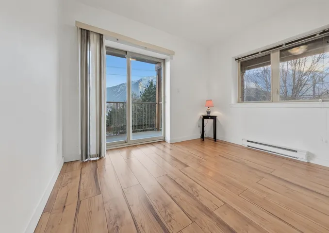 Sliding glass door opening to a private balcony with mountain scenery