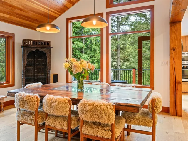 Vaulted wood-paneled ceiling with exposed beams, wood-finish flooring, and large picture windows