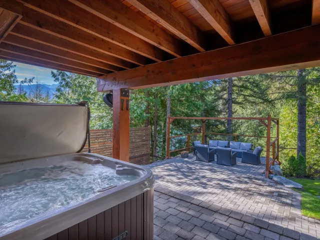 Covered outdoor hot tub area with exposed timber beams and support posts
