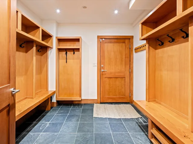 Entryway featuring slate tile flooring, built-in wooden cabinetry with benches and storage cubbies, and recessed ceiling lighting