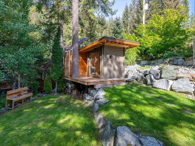 Outdoor structure featuring wood-finish siding and a flat roof with exposed wood beams