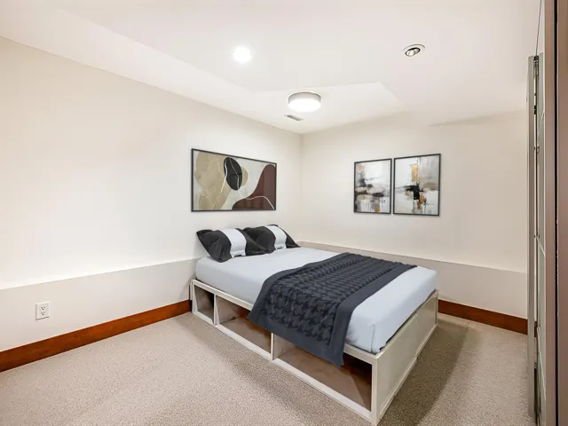 Recessed ceiling lighting, a contemporary flush-mount light fixture, and light-colored carpeting