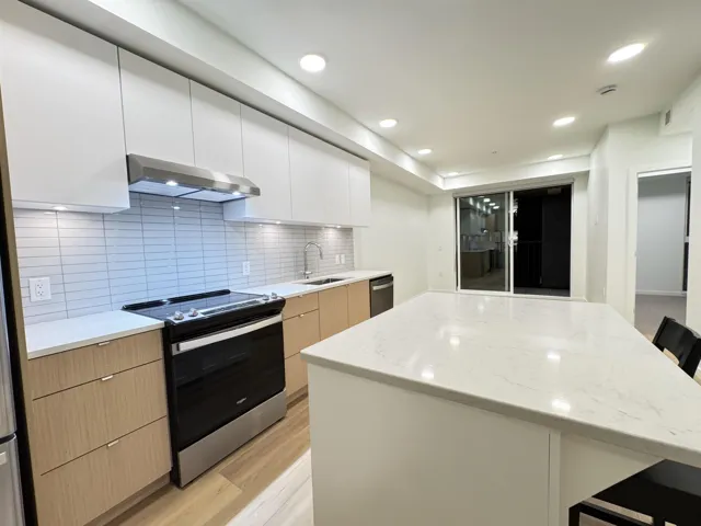 Kitchen with a breakfast bar area, stainless steel appliances, white cabinetry, modern cabinets, and recessed lighting